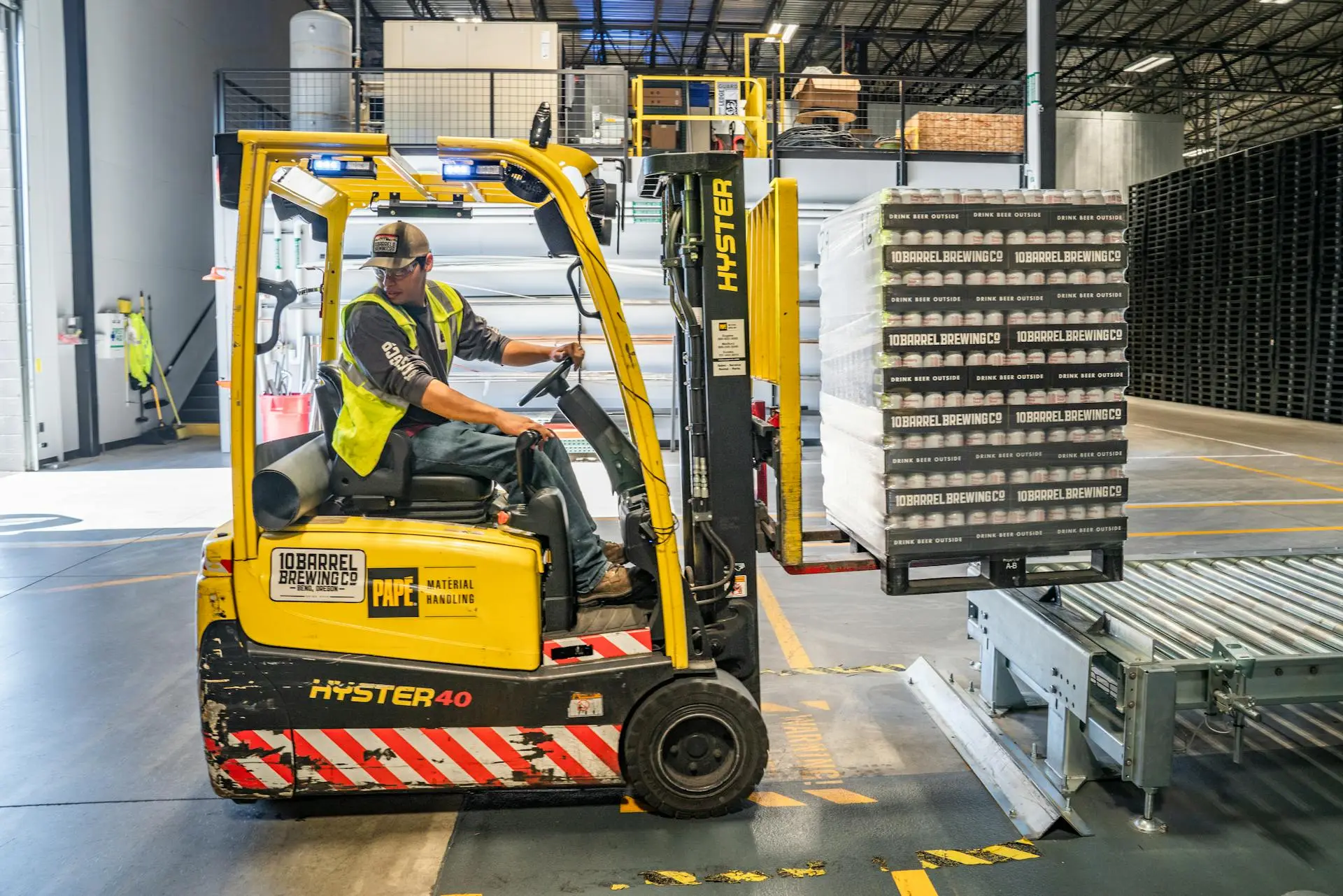 Male worker in forklift in industrial warehouse